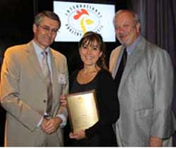 Adriana Navarro (centro) de FENAVI Colombia, acepta el premio de mercadeo genérico de Jim Sumner (der) y Robin Horel.